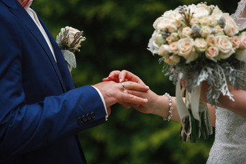 the bride wears the bride's wedding ring wedding ceremony of a happy young couple.  The brides are exchanging wedding rings. Wedding day.