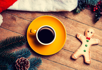 Coffee with gingerbread man on wooden table.