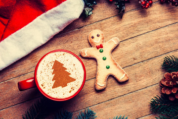 Coffee with gingerbread man on wooden table.