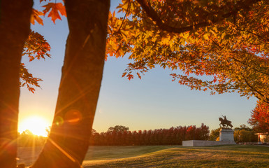 October 20, 2018 - St. Louis, Missouri - The sunrise and fall foliage around the Apotheosis of St. Louis statue of King Louis IX of France on Art Hill in Forest Park, St. Louis, Missouri. - obrazy, fototapety, plakaty