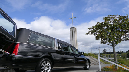Shot of hearse arriving or leaving a funeral