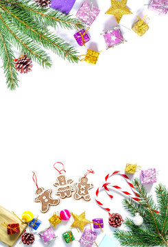Branch of a Christmas tree with balls, fir cones, traditional candies and boxes with gifts isolated on a white background. Christmas and New Year background with free space for text.