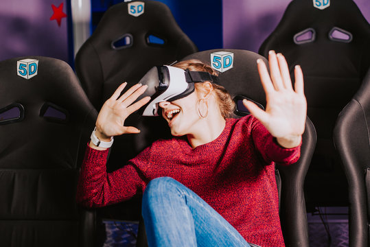 beautiful girl in virtual glasses is watching a movie with special effects in 5d