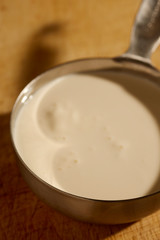 about 3/4 of a cup of American heavy cream in a steel measuring cup.