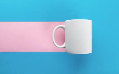 White mug on blue and pink background