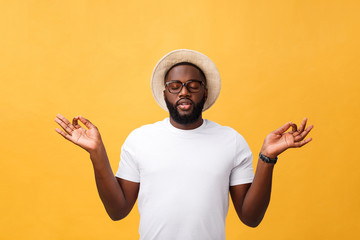 Closeup portrait of happy handsome, young man in meditation yoga mode, isolated on yellow background. Stress relief techniques concept.
