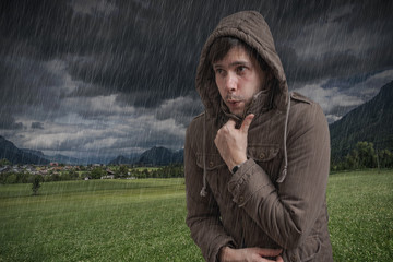 Young man feeling cold during thunderstorm.