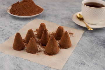 Sweet dessert - chocolate candy truffles, tea in a Cup, cocoa powder for powder.