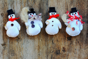 Vier Schneemänner auf einem Holzuntergrund. Weihnachtlicher Hintergrund