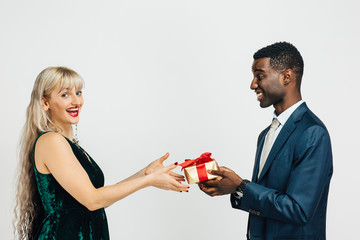 Young woman receiving a beautiful gift from young man in suit