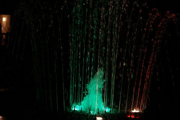 Colorful musical fountain at night, shimmering in different colors