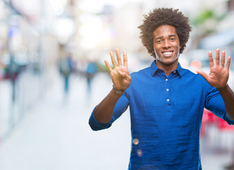 Afro american man over isolated background showing and pointing up with fingers number nine while smiling confident and happy.