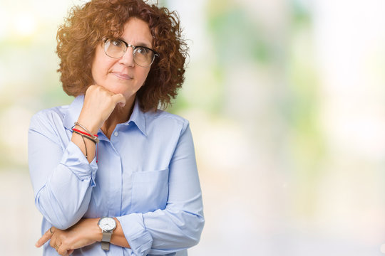 Beautiful middle ager senior businees woman wearing glasses over isolated background with hand on chin thinking about question, pensive expression. Smiling with thoughtful face. Doubt concept.