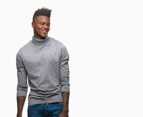Fototapeta premium Young african american man over isolated background looking away to side with smile on face, natural expression. Laughing confident.