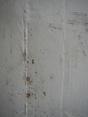 Dirty white painted reinforced concrete wall on construction site on balcony of apartment before renovation