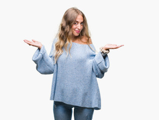 Beautiful young blonde woman wearing winter sweater over isolated background clueless and confused...