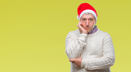 Handsome senior man wearing christmas hat over isolated background thinking looking tired and bored with depression problems with crossed arms.
