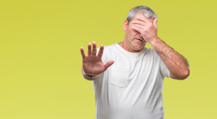 Handsome senior man over isolated background covering eyes with hands and doing stop gesture with sad and fear expression. Embarrassed and negative concept.