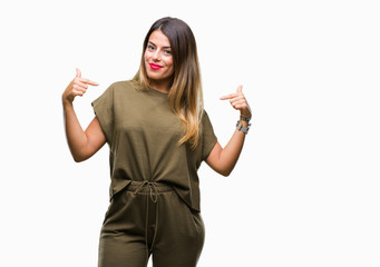 Young beautiful woman over isolated background looking confident with smile on face, pointing...