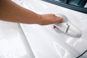 Close-Up of Woman Hand is Holding Handle Car Door While Open, Body Part of Female Hand Unlock Vehicle Car for Entering to Drive. Automotive Security and Personal Transport Concept