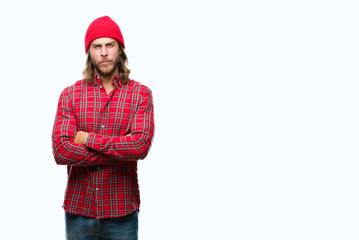 Young handsome man with long hair wearing red cap over isolated background skeptic and nervous,...