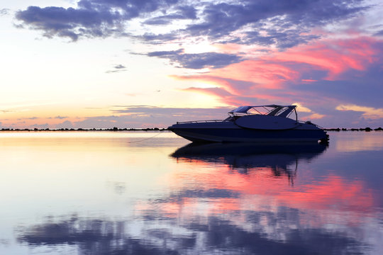 Fototapeta speed boat in the sea with beautiful sunrise