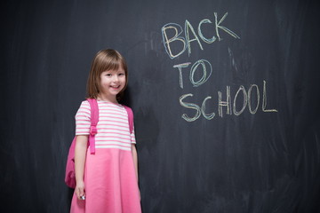 school girl child with backpack writing  chalkboard