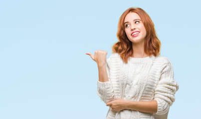 Fototapeta premium Young beautiful woman over isolated background wearing winter sweater smiling with happy face looking and pointing to the side with thumb up.