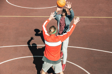 Basketball game. Pleasant young man catching the ball while playing basketball game
