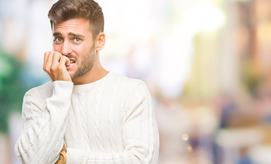 Young handsome man wearing winter sweater over isolated background looking stressed and nervous with hands on mouth biting nails. Anxiety problem.