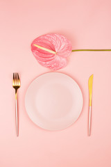 Pink plate and cutlery on the pink background