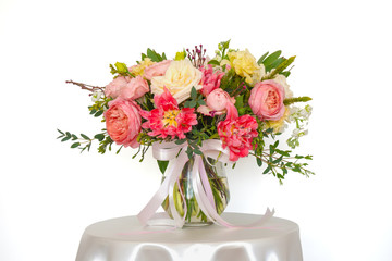 flowers arrangement with variety kind of flowers in glass vase on round table on white background with clipping path