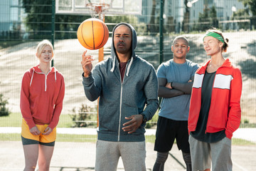 Real professional. Pleasant nice man standing in front of the team while showing them his skills with a ball