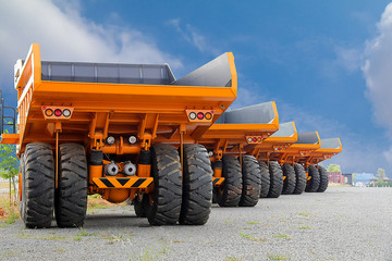 Big dumper trucks parked on a construction site on blue sky © Mr.B-king