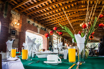 interior de restaurante rustico de madera con desayuno y flores en la mesa