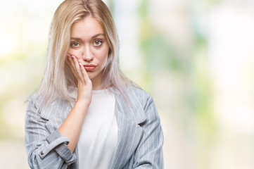 Young blonde business woman wearing jacket over isolated background thinking looking tired and bored with depression problems with crossed arms.