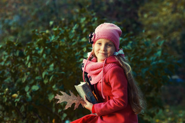 portrait of a girl in an autumn Park, a child dressed in a red warm coat