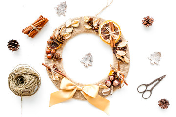 Christmas decoration concept. Creative christmas wreath made of thread near matherials and instruments, sciccors on white background top view