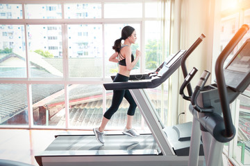 Fototapeta premium young healthy sport woman running or walking on exercise machine in gym (workout concept)