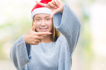 Young beautiful caucasian woman wearing christmas hat over isolated background smiling making frame...