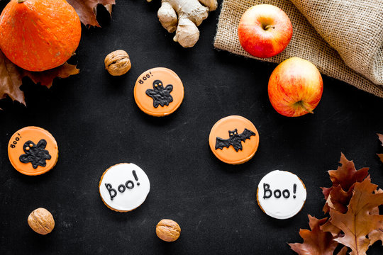 Halloween composition with autumn harvest as dried autumn leaves, pumpkin, apple and cute round hallooween badges with rats, ghousts, Boo text on black background top view pattern