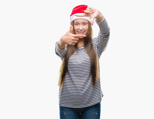 Young beautiful caucasian woman wearing christmas hat over isolated background smiling making frame with hands and fingers with happy face. Creativity and photography concept.