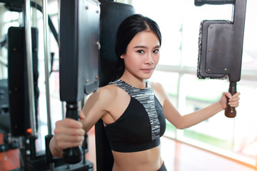 Fototapeta na wymiar portrait of young healthy and sporty woman using exercise machine in gym