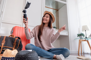 Asian young female blogger recording vlog video with mobile phone live streaming when travel.online...