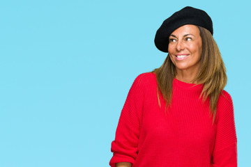 Middle age adult woman wearing fashion beret over isolated background looking away to side with smile on face, natural expression. Laughing confident.