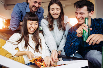 Group of best friends spending time at home party. Drinking beer, eating pop corn together. Multi ethnic people