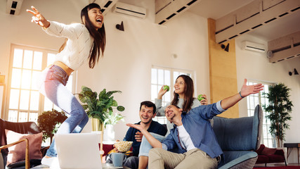 Group of friends at home party. Dancing on the table and playing funny games together