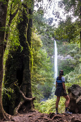 Young woman near a hidden waterfall near Pucon, Chile