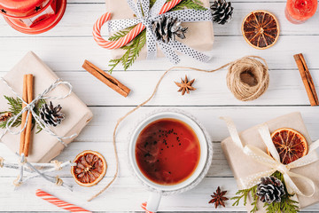 Christmas composition with gift boxes, pine cones, dried oranges and cinnamons on a wooden white...