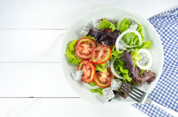 Healthy salad bowl props decoration kiwi, tomatoes, apple,Green pepper, lime and mixed greens, lettuce, vitamin snack on white wooden background top view, Food and health..